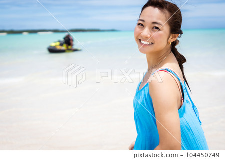 年輕女子在海灘度假村微笑著回頭 104450749