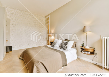 a bedroom with wood flooring and white wallpapers on the walls, along with a bed that has a brown comforter a bedroom with wood flooring and white wallpapers on the walls, along with a bed that has a brown comforter 104452298