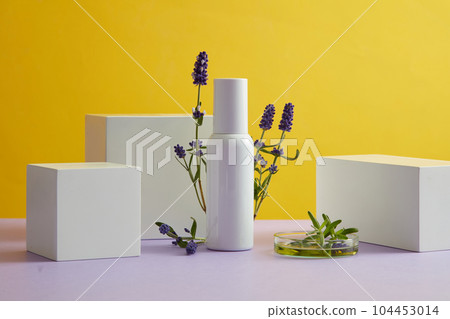 Against the yellow background, white bottle unbranded displayed with fresh lavender flower and white geometric podiums. Mockup scene with space for design packaging. Front view Against the yellow background, white bottle unbranded displayed with fresh lavender flower and white geometric podiums. Mockup scene with space for design packaging. Front view 104453014