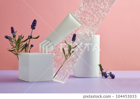 Cosmetic mockup with lavender flower and white geometric podiums decorated on pink background. Front view, white bottle unlabeled for design. Lavender is a famous and popular flower around the world 104453033