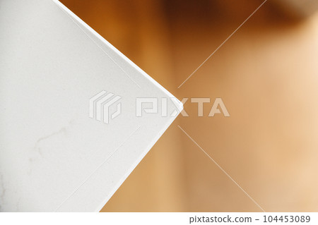a piece of paper that has been cut in half and is being held up by a person's hand a piece of paper that has been cut in half and is being held up by a person's hand 104453089