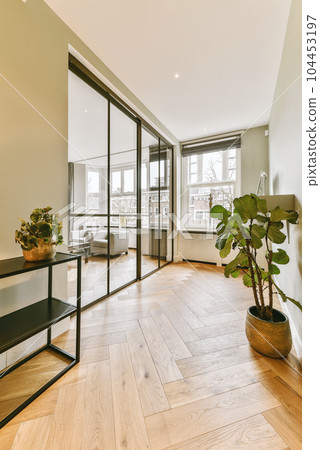 a living room with wood flooring and large glass doors leading to the balcony area in the room is empty 104453197