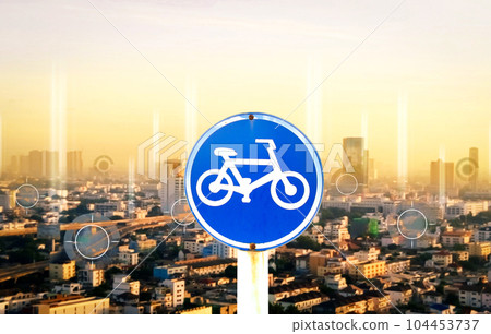 Bicycle road sign with cityscape background at sunset, transportation concept 104453737