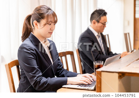 Asian business woman in suit using laptop at cafe counter 104453791