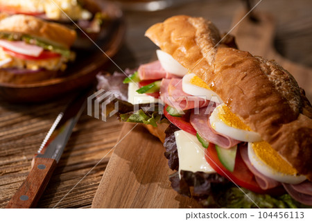 Egg, cheese, ham, baguette sandwich with plenty of vegetables 104456113