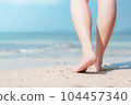 Close up woman legs walking on tropical beach with smooth wave abstract background. Travel vacation and freedom feel good concept. Vintage tone filter color style. 104457340