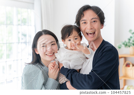 A smiling family of three spending time at home (family, childcare, childcare, baby) A smiling family of three spending time at home (family, childcare, childcare, baby) 104457825