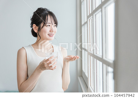 年輕的亞洲女性服用藥物、補充劑、維生素、抗脹氣藥 104457942