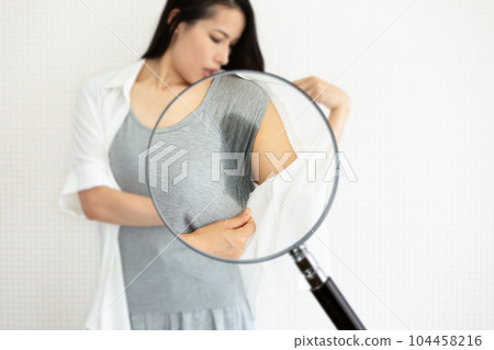 The sweat stains are magnified with a magnifying glass. The sweat stains are magnified with a magnifying glass. 104458216