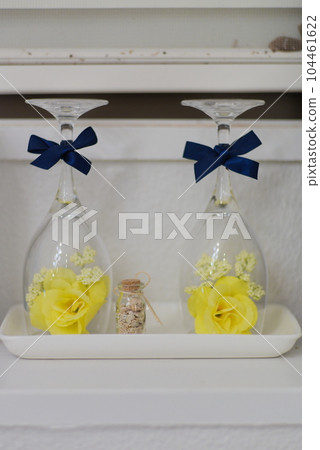 Yellow flower decoration with an inverted wine glass 104461622