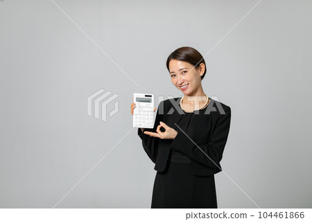 A woman holding a calculator Peace of mind 104461866