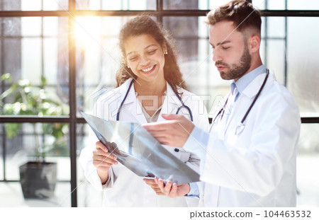 Two busy doctors working with papers and xray images Two busy doctors working with papers and xray images 104463532