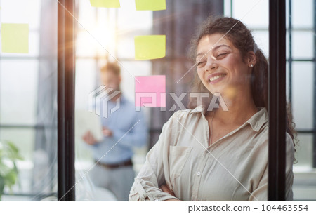 Smiling business woman looking out the window. 104463554