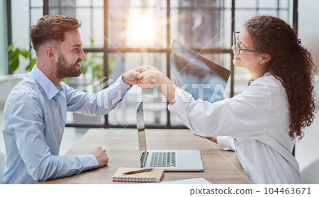 woman doctor holding an x-ray in her hands shakes hands with a patient woman doctor holding an x-ray in her hands shakes hands with a patient 104463671