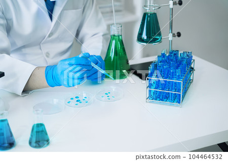 Science and medicine, scientist analyzing and dropping a sample into a glassware, experiments containing chemical liquid in laboratory on glassware, innovative and technology. Science and medicine, scientist analyzing and dropping a sample into a glassware, experiments containing chemical liquid in laboratory on glassware, innovative and technology. 104464532