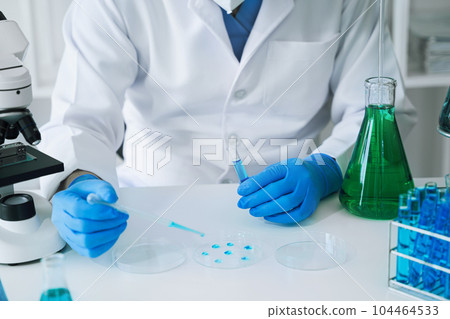 Science and medicine, scientist analyzing and dropping a sample into a glassware, experiments containing chemical liquid in laboratory on glassware, innovative and technology. Science and medicine, scientist analyzing and dropping a sample into a glassware, experiments containing chemical liquid in laboratory on glassware, innovative and technology. 104464533