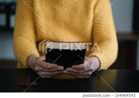Closeup of simple wooden Christian cross on Bible. Concept of hope, faith, christianity, religion. Closeup of simple wooden Christian cross on Bible. Concept of hope, faith, christianity, religion. 104464542