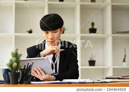 Image of businessman in formalwear analyzing statistics data on digital tablet 104464950