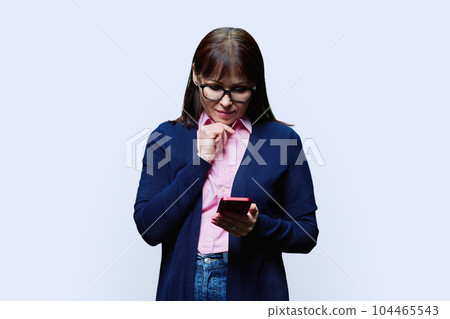 Middle aged woman using smartphone, on white background Middle aged woman using smartphone, on white background 104465543