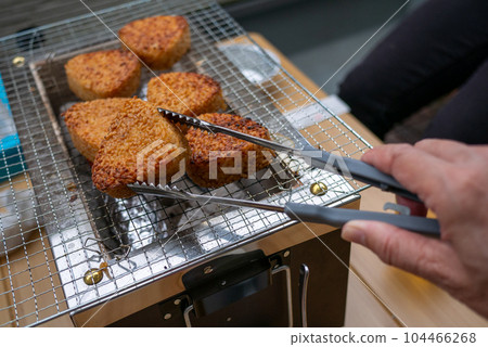 屋子的陽台上,正在網上烤著燒烤用的烤飯糰。 屋子的陽台上,正在網上烤著燒烤用的烤飯糰。 104466268