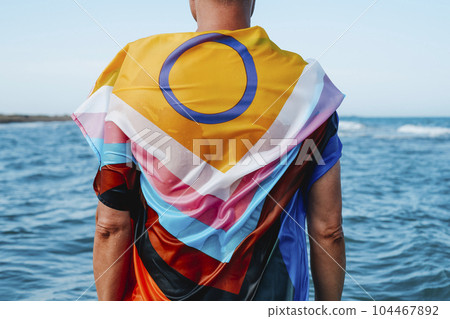person in the sea wrapped in a progress pride flag 104467892