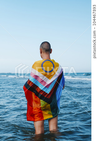 man in the sea wrapped in a progress pride flag man in the sea wrapped in a progress pride flag 104467893