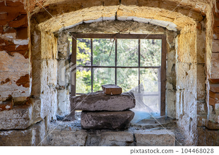A damaged window with bars in an abandoned building A damaged window with bars in an abandoned building 104468028