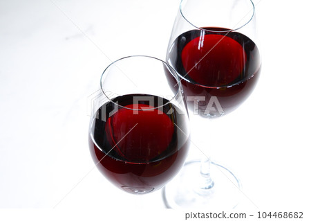 Two wine glasses filled with red wine Two wine glasses filled with red wine 104468682