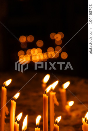 A lot of burning candles in the temple in the dark. The concept of religion, prayer and God. 104468798