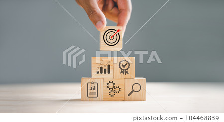 Wood block stacking arranged by a hand, representing a business strategy and Action plan. Targeting the concept of procedure and systematic work approach. Wood block stacking arranged by a hand, representing a business strategy and Action plan. Targeting the concept of procedure and systematic work approach. 104468839