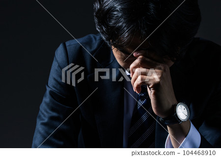 A businessman who is depressed at work 104468910