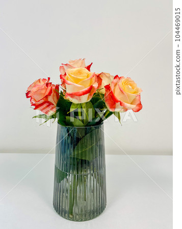 Bouquet of beautiful roses housed in a glass vase in the office. Bouquet of beautiful roses housed in a glass vase in the office. 104469015