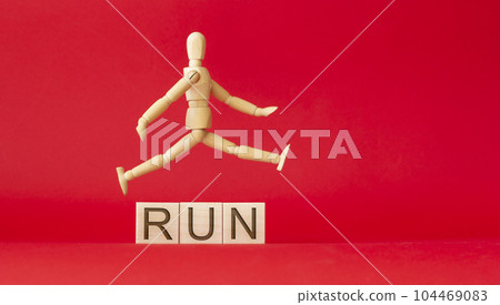 running doll on a red background with wooden cubes 104469083