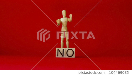 Wooden doll near cubes with text no on a red background 104469085