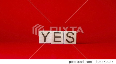 text yes written on wooden blocks, on a red background text yes written on wooden blocks, on a red background 104469087