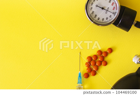 Bunch of pills and capsules and medical stethoscope and blood pressure meter on yellow background Bunch of pills and capsules and medical stethoscope and blood pressure meter on yellow background 104469100