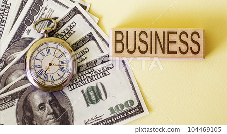 On a yellow background, American banknotes, watches and text business. 104469105