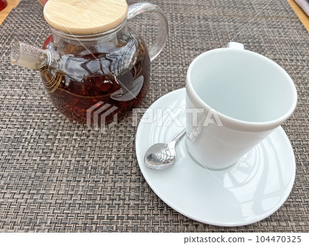 Teapot with tea and a cup on the table Teapot with tea and a cup on the table 104470325