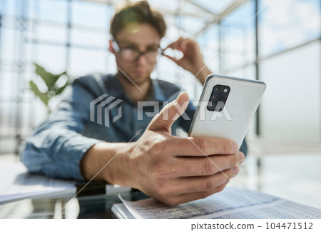 businessman professional executive holding mobile working at desk with smartphone. businessman professional executive holding mobile working at desk with smartphone. 104471512