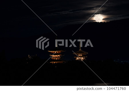 Autumn moonrise and night view of Yakushiji Temple peeking through the clouds Autumn moonrise and night view of Yakushiji Temple peeking through the clouds 104471760