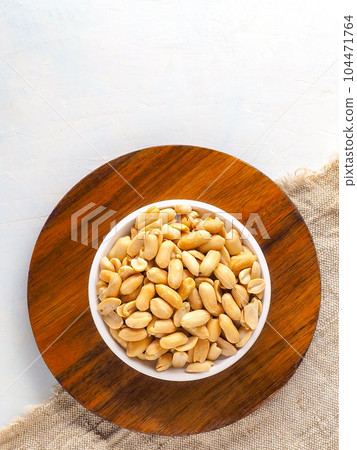 Cup with peeled selected peanuts on light background with copy space. Advertising photography for Cup with peeled selected peanuts on light background with copy space. Advertising photography for 104471764