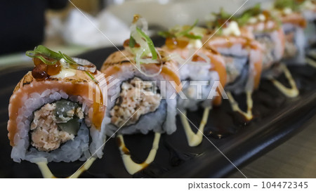 Salmon Oyako Spicy roll consist of crispy salmon skin is wrapped with sushi rice, topped with half broiled Aburi Salmon with spicy sauce Salmon Oyako Spicy roll consist of crispy salmon skin is wrapped with sushi rice, topped with half broiled Aburi Salmon with spicy sauce 104472345