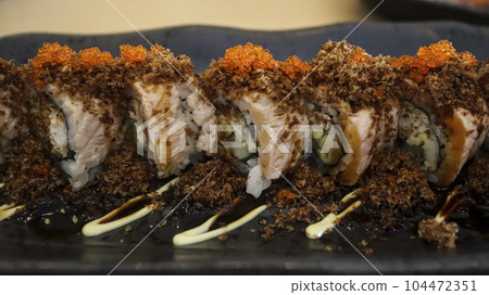Aburi Salmon Roll consist of crab meat with soft shell crab, sushi rice and rolled up. After that, the top is given aburi which is grilled fish meat that comes from a combination of salmon and tuna. 104472351