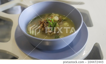 Oxtail soup is a soup made with beef tails served in a table Oxtail soup is a soup made with beef tails served in a table 104472443