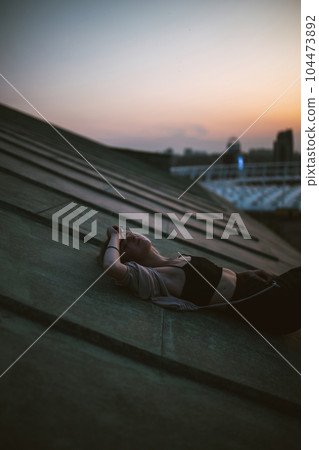 Photo shoot on roof. Young woman posing in roof at sunset. People, lifestyle, relaxation concept. Photo shoot on roof. Young woman posing in roof at sunset. People, lifestyle, relaxation concept. 104473892
