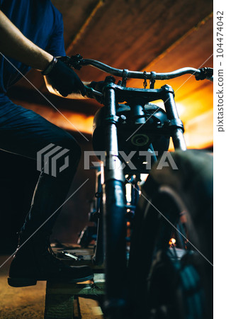 Motorcycle repair. The expert works with electric welding of metal. Instruments and equipment. 104474042