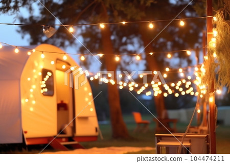 Blurred photo of camping tents with lighting decoration at night 104474211