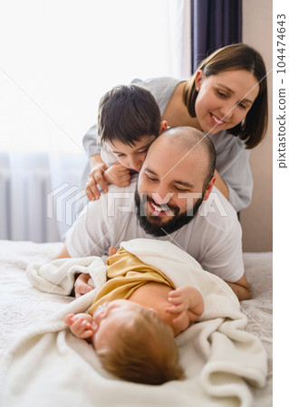 Happy family of four with newborn baby 104474643
