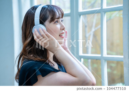 聽到與耳機的音樂的一個少婦 104477310