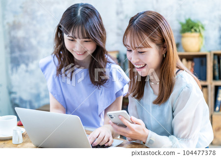 Two young women planning a trip Two young women planning a trip 104477378